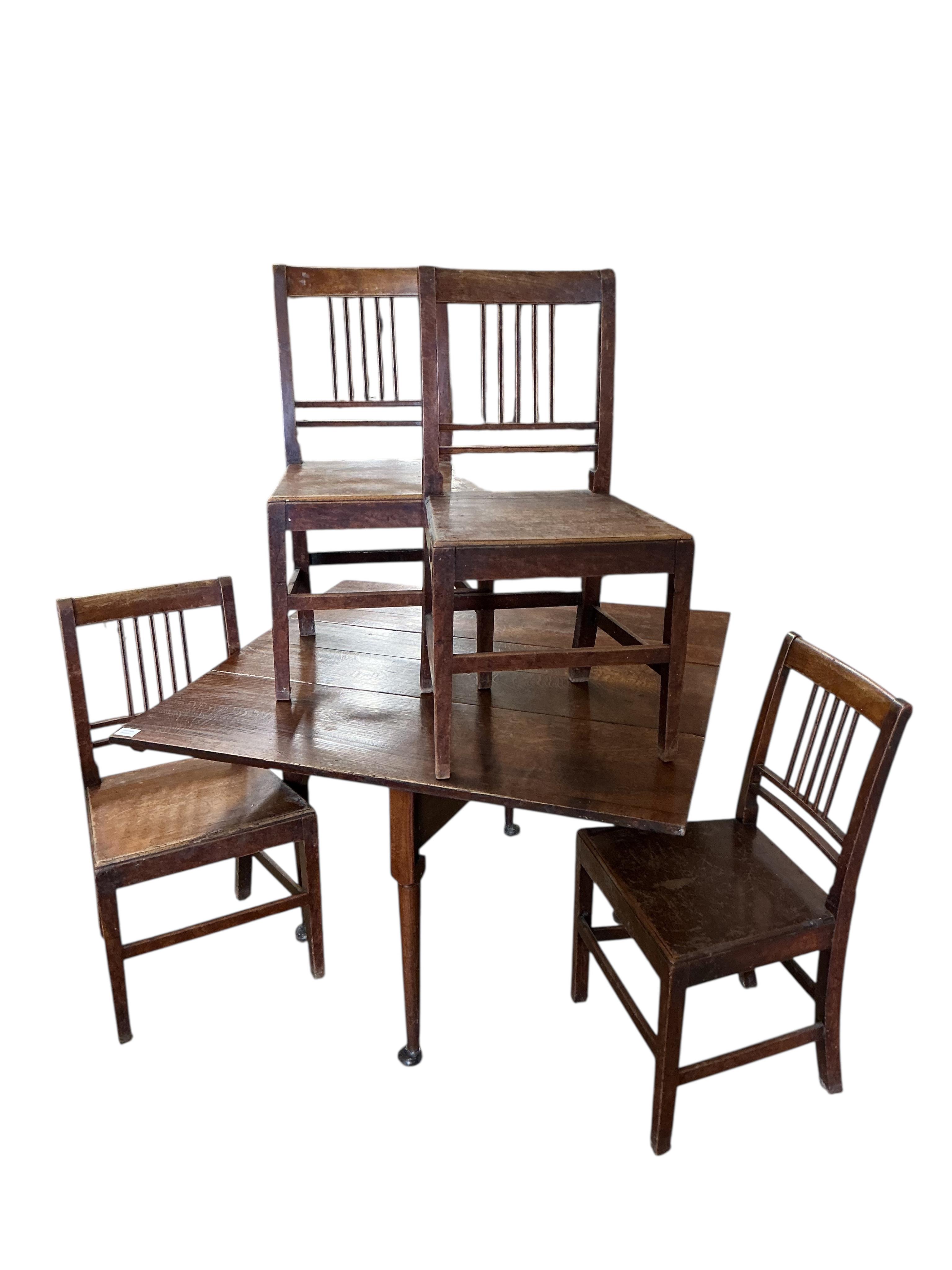 A George III oak drop leaf dining table, width 112cm, depth 42cm, height 71cm together with four George III Provincial mahogany wood seat dining chairs